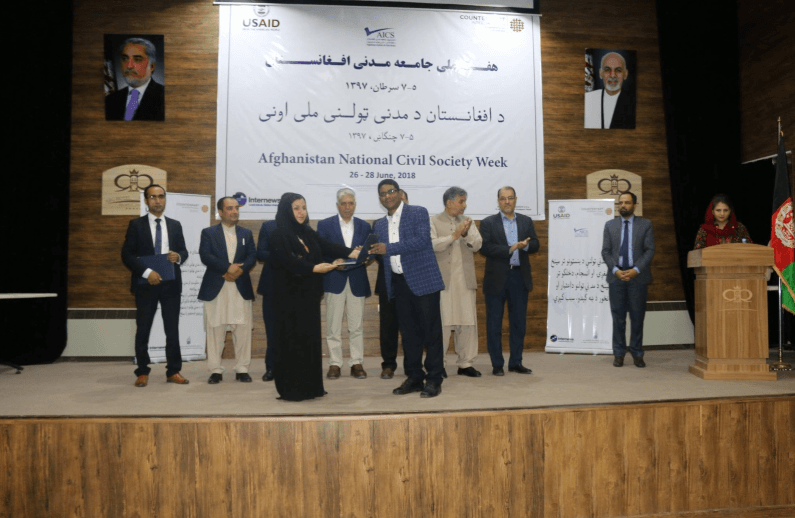Handing a Gift to the Executive Director of Afghan CSO during Civil Society Week.